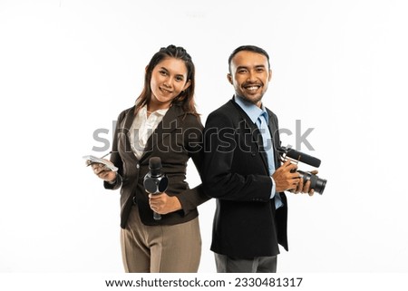 a beautiful journalist with long brown hair wearing brown blazer standing next to the male journalist in blue shirt and black suit Royalty-Free Stock Photo #2330481317