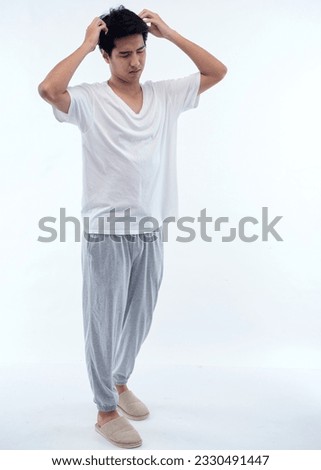 Sleepy young man in pajamas on white background