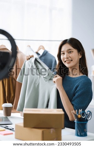 Asia vlogger woman influencer, SME retail store owner smile enjoy selling show live sale online screen smartphone and laptop work at home. Royalty-Free Stock Photo #2330493505