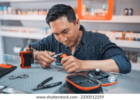 male shopkeeper changing the vape cotton coil seriousely at the vape store