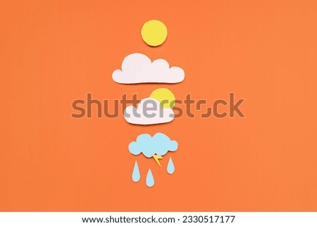 Paper sun with clouds and rain drops on red background. Weather forecast concept Royalty-Free Stock Photo #2330517177