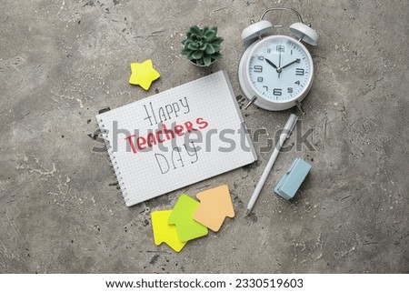 Notebook with text HAPPY TEACHERS DAY, alarm clock and different stationery on grunge grey background