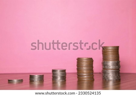 Stacking coins on the wooden table and growth graph to save money or investment to get business income by finance  marketing
