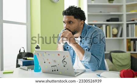 African american man student using laptop studying at library university