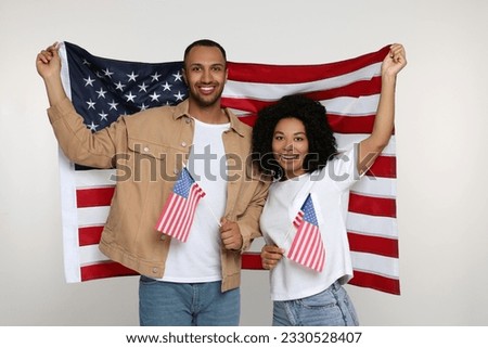 4th of July - Independence Day of USA. Happy couple with American flags on white background