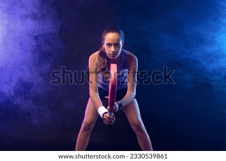 Junior padel tennis player with racket. Open day. Girl athlete with paddle racket on court. Sport concept. Download a high quality photo for the design of a sports app or social media publication. Royalty-Free Stock Photo #2330539861