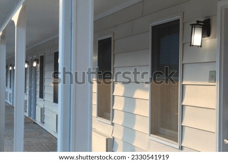 A photo of a warm evening sun reflecting onto the doors of motel rooms.