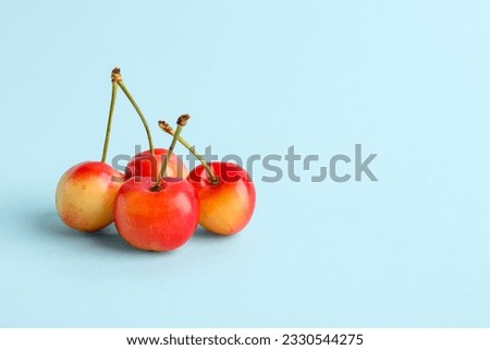 Sweet yellow cherries on blue background Royalty-Free Stock Photo #2330544275