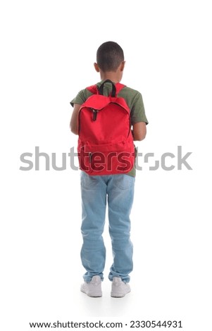 Little African-American schoolboy with backpack on white background, back view Royalty-Free Stock Photo #2330544931