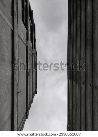 Portrait of a tall building against a white cloud background