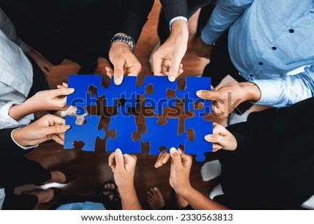 Top view multiethnic business people holding jigsaw pieces and merge them together as effective solution solving teamwork, shared vision and common goal combining diverse talent. Meticulous Royalty-Free Stock Photo #2330563813
