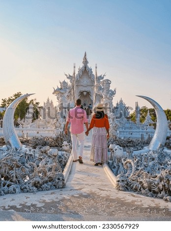 couple of men and women visiting the white temple in Chiang Rai during sunset in Thailand Royalty-Free Stock Photo #2330567929
