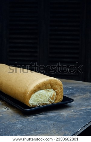 Roll cake with cream and cheese filling, a type of cake that is baked using a shallow pan, filled with butter cream and cheese and then rolled up.