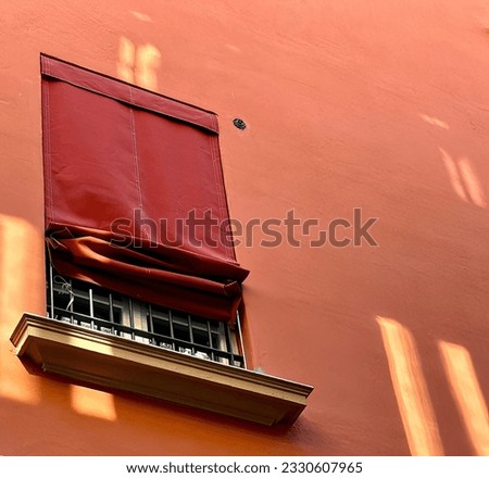 Red shades on the windows of Bologna Italy are commonplace.  They are heavy and block the harsh rays of the sun but still provide an elegant experience to the wayfarer. Royalty-Free Stock Photo #2330607965