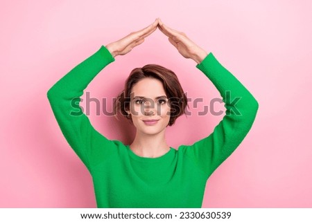 Photo of stunning charming young girl wear green shirt showing hands palms above head roof protection isolated on pink color background