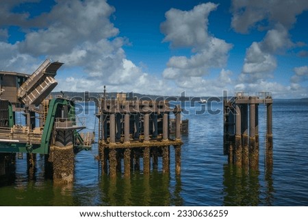 THE MUKILTEO FERRY DOCK WITH A FERRRY IN THE DISTANCAE COMING TO UNLOAD WITH A NICE SKY AND A CLAM PUGET SOUND IN WASHINGTON STATE Royalty-Free Stock Photo #2330636259