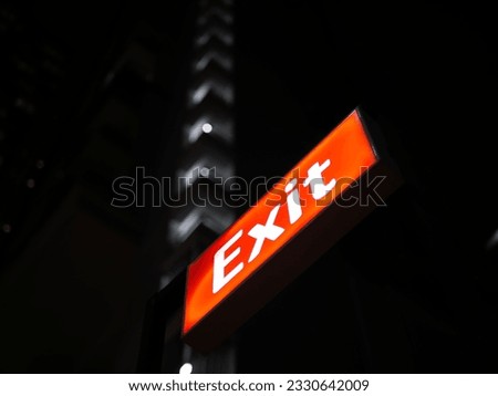 Exit Sign Red Light Color With Building Background at Night Bokeh