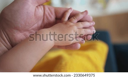 hand of a newborn baby. happy family toddler dream concept. father holding baby hand close-up. dad holding the hand of newborn toddler. child birth lifestyle protection care concept Royalty-Free Stock Photo #2330649375