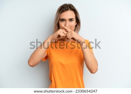 young adult pretty woman looking serious and displeased with both fingers crossed up front in rejection, asking for silence