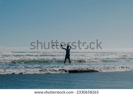 boom operator picking up the sound of waves crashing on the beach during a film production