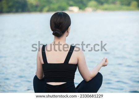 Beautiful asian woman meditating in the park. Yoga concept.