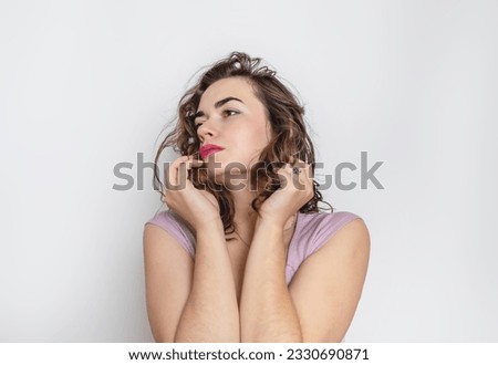 Pensive woman with hand near face. Dark wavy hair, black eyebrows, big brown eyes