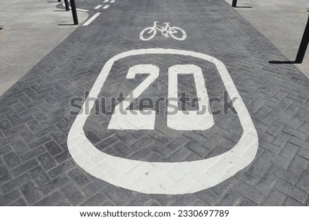 Close up of street 20 speed limit  and bicycle sign painted on cobblestone street in Sant Joan D'Alacant in costa blanca region of Spain