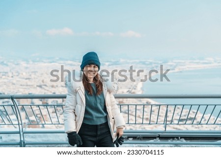 Woman tourist Visiting in Hakodate, Traveler in Sweater sightseeing view from Hakodate mountain with Snow in winter. landmark and popular for attractions in Hokkaido, Japan.Travel and Vacation concept Royalty-Free Stock Photo #2330704115