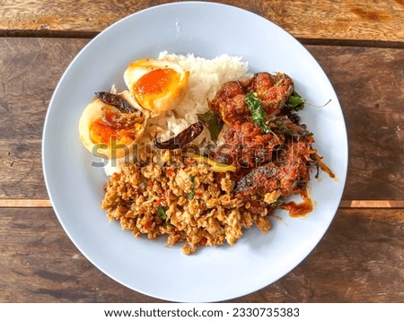 The concept of economic dish meal as curry and rice in Thai's style canteen. Normally, people go to eat in canteen or cafeteria and get rice with various kinds of curry and food. Royalty-Free Stock Photo #2330735383