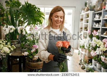 Woman florist flower shop owner hold roses on floral background. High quality photo