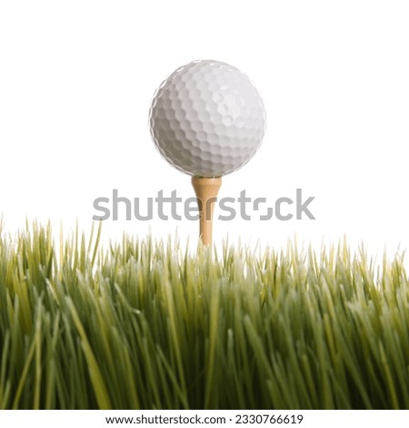 Studio shot of golf ball resting on tee in grass.