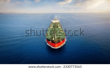 Aerial front view of a heavy crude oil tanker traveling over calm sea during sunset Royalty-Free Stock Photo #2330773563