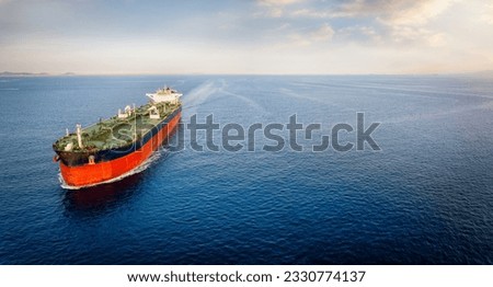 Aerial view of a large crude oil tanker traveling over calm sea during sunset with copy space Royalty-Free Stock Photo #2330774137