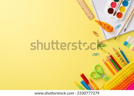 Studying art at school concept. Above view photo of album, watercolour paints and vivid stationery on yellow isolated background with copy-space for advertising or text messages