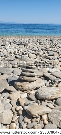 Stone pyramid on a pebble beach, symbolizing stability, zen, harmony, balance. rest and relaxation by the sea or ocean. holiday travel destination