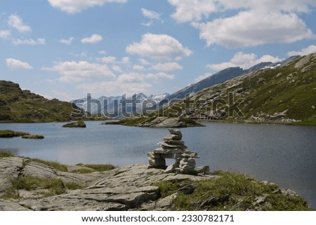 Stones piled up in a sign of positivity and energy in a lake in the Swiss Alps at the Bernardino Pass