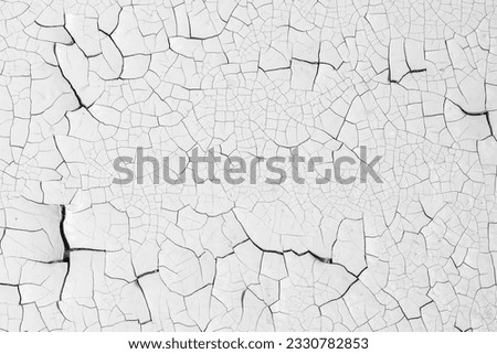 White peeling paint on the wall. Old concrete wall with cracked flaking paint. Weathered rough painted surface with patterns of cracks and peeling. High resolution texture for background and design. Royalty-Free Stock Photo #2330782853