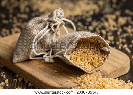 Not cooked wheat porridge in a linen bag , fresh crushed wheat groats close- up in a bag Royalty-Free Stock Photo #2330786347
