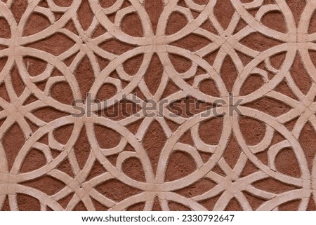 Stone facade, moorish and islamic style, with geometric shapes, lines, circles and floral patterns on a building in Segovia, Spain, brown and beige colors.