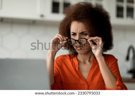 Black freelancer woman with bad eyesight taking off glasses while using laptop at home, young african american female looking at computer screen and squinting, having vision troubles, closeup Royalty-Free Stock Photo #2330795033