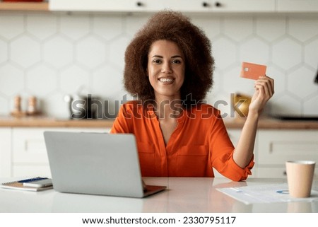 Online Payments. Young Black Lady Using Laptop And Credit Card In Kitchen, African American Woman Using Computer At Home, Paying Utilities Or Shopping In Internet, Enjoying E-Banking, Free Space
