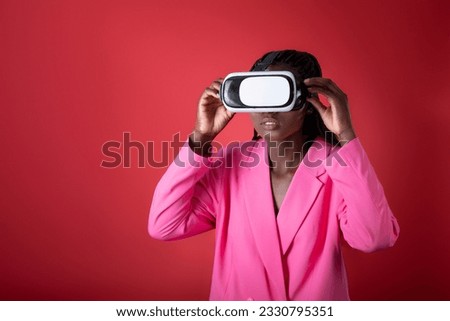 Young Black Female Wearing VR Glasses Headset Posing Over Red Background, Stylish African American Woman Experiencing Virtual Reality, Enjoying Modern Technologies For Entertainment, Copy Space