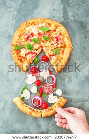 Hand holds a cut piece of pizza on a gray background. Ingredients for pizza.