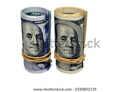 Rolls of 100 one hundred dollar banknote currency cash money old and new series rolled up with rubber bands with the portrait of president Benjamin Franklin on obverse and independence hall on reverse