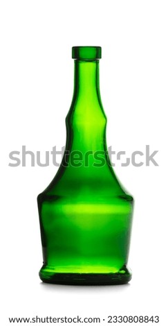 An empty bottle for alcoholic beverages made of dark green glass of a beautiful unusual shape, isolated on a white background. Bottle for cognac, whiskey, brandy. Royalty-Free Stock Photo #2330808843