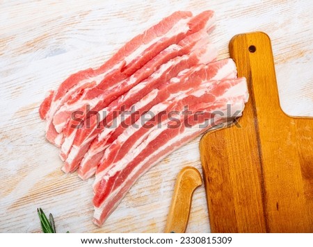 Close up of raw bacon steaks on wooden surface, nobody