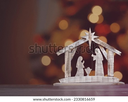 A wooden Christmas Nativity set with the holy family gazing at baby Jesus with a bokeh background. Royalty-Free Stock Photo #2330816659