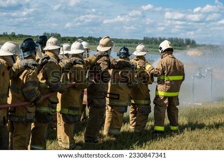 Firefighters and rescue training. Firefighter spraying high pressure water to fire Burning fire flame background