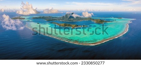 Above the Clouds: Aerial view of Bora Bora, French Polynesia and its surrounding lagoon and barrier reef Royalty-Free Stock Photo #2330850277