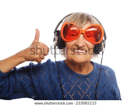 Funny old lady listening music and showing thumbs up. Isolated on white. 